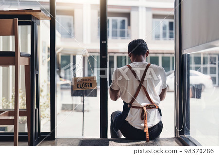 Young male manager in restaurant. Man coffee shop owner with close sign. Small business concept Young male manager in restaurant. Man coffee shop owner with close sign. Small business concept 98370286