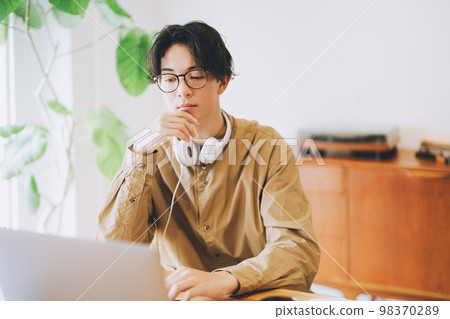 A man who uses a personal computer at home 98370289