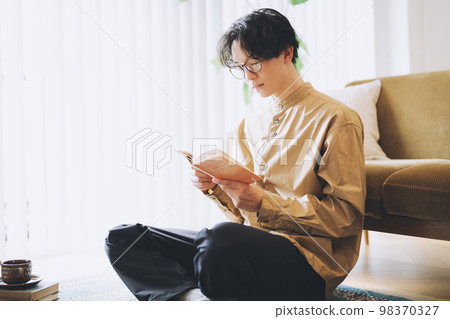 Man with glasses reading a book 98370327