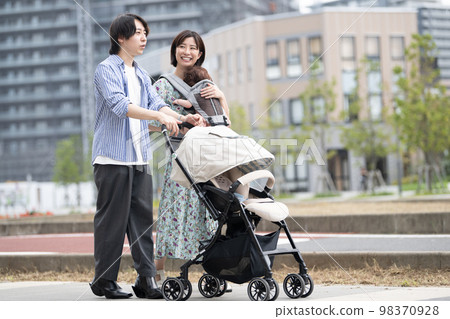 A couple raising children walking in the city 98370928