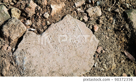 Close-up view to plate with cuneiform Sumerian text at the Ruins of Processional street of ancient Babylon, Hillah, Iraq Close-up view to plate with cuneiform Sumerian text at the Ruins of Processional street of ancient Babylon, Hillah, Iraq 98372356
