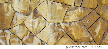 Sturdy yellow and beige cut stone wall, seamless lined up 98372430