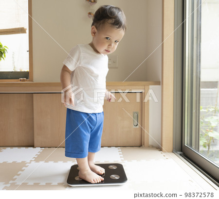 A 2-year-old child on a scale 98372578