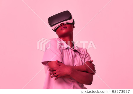 A cheerful girl in virtual reality glasses. Blue and purple colors. 98373957