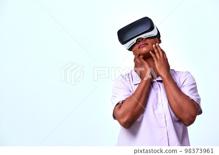 A cheerful girl in virtual reality glasses. Blue and purple colors. A cheerful girl in virtual reality glasses. Blue and purple colors. 98373961