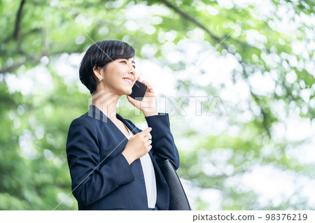 一個穿著西裝的女商人在用智能手機說話 98376219