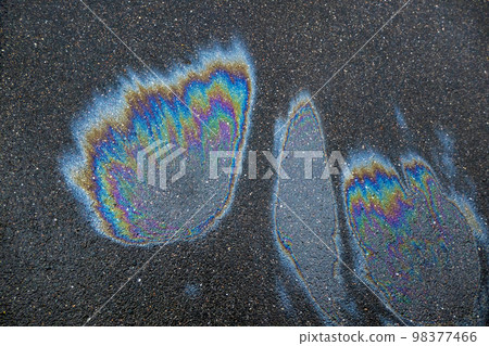 Iridescent spot of gasoline. Petrol on the asphalt a big polluted puddle water. A rainbow slick of gasoline 98377466