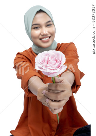 Asian Muslim woman in a headscarf holding a rose flower 98378017