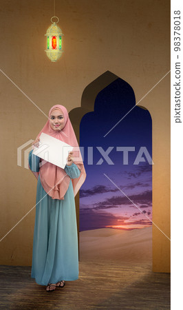 Asian Muslim woman in veil holding empty paper 98378018