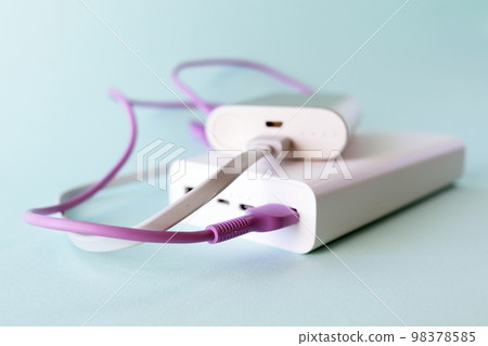 Power bank, external battery and usb wire on the table, universal mobile battery for charging gadgets, for recharging a smartphone Power bank, external battery and usb wire on the table, universal mobile battery for charging gadgets, for recharging a smartphone 98378585