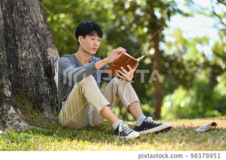 Peaceful young asian man student reading a book in the park, preparing for exams at the university or college Peaceful young asian man student reading a book in the park, preparing for exams at the university or college 98378951