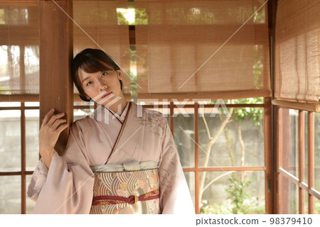 一個穿著和服的美麗年輕女子在一座古老的民居 一個穿著和服的美麗年輕女子在一座古老的民居 98379410