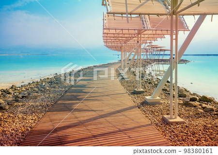Seascape. The shore of the Dead Sea. Beach with a wooden walkway and sunshades. Summer. Israel 98380161