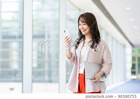 Young engineer looking at smartphone Young engineer looking at smartphone 98380755