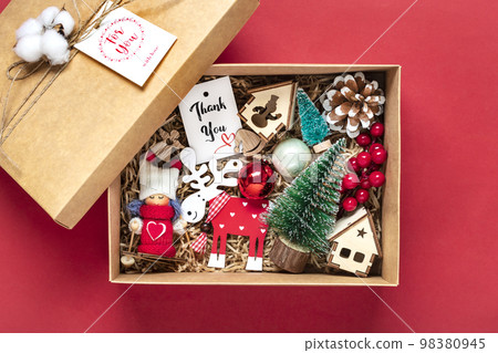Handmade care package, seasonal gift box with toys, xmas decor on red table Personalized eco friendly basket for family, friends, girl for 24 December, Christmas, New Year day Flat lay. Handmade care package, seasonal gift box with toys, xmas decor on red table Personalized eco friendly basket for family, friends, girl for 24 December, Christmas, New Year day Flat lay. 98380945