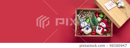 Handmade care package, seasonal gift box with toys, xmas decor on red table Personalized eco friendly basket for family, friends, girl for 24 December, Christmas, New Year day Flat lay. 98380947