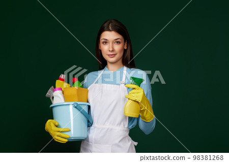 woman in cleaner apron holding bucket of detergents 98381268