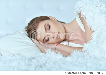 young woman lying on soft bed in the bedroom 98382017