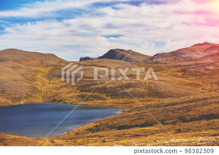 Beautiful lake at sunset. Wild nature of Norway. Nordkapp (North Cape), Mageroya island Beautiful lake at sunset. Wild nature of Norway. Nordkapp (North Cape), Mageroya island 98382309