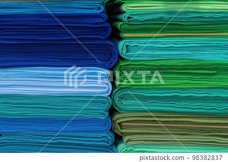Layers of colorful fabric, colorful background. Pile of bright rolls of fabric. Layers of colorful fabric, colorful background. Pile of bright rolls of fabric. 98382837