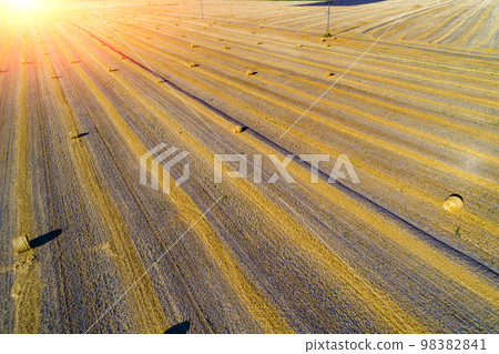 Aerial top view of the colorful geometric wheat fields with straw bales. Baling straw Aerial top view of the colorful geometric wheat fields with straw bales. Baling straw 98382841