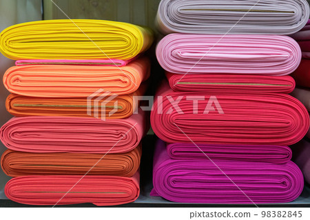 Layers of colorful fabric, colorful background. Pile of bright rolls of fabric. Layers of colorful fabric, colorful background. Pile of bright rolls of fabric. 98382845
