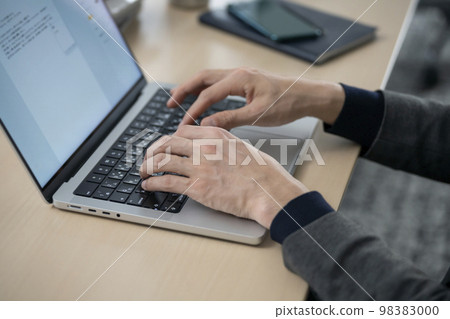 一個 30 多歲的男人在筆記本電腦上打字的手 98383000