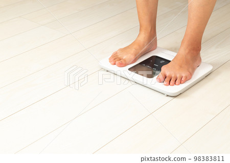 Women's feet on a scale Women's feet on a scale 98383811