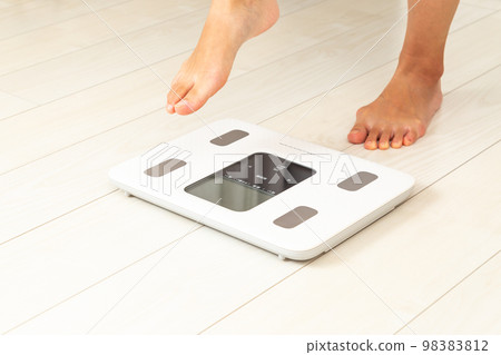 Women's feet on a scale Women's feet on a scale 98383812