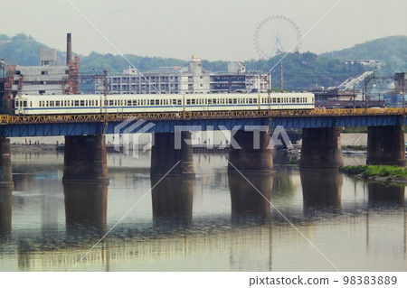 1980 年 4 月 28 日，KR 小田急 2400 系列穿越多摩川，在向之丘遊樂園“花大階梯”和摩天輪後面 98383889