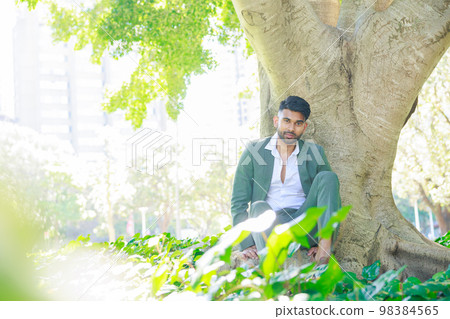 坐在一棵大樹下的西裝的印地安人 98384565