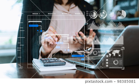 Businessman hand Project manager working and update tasks and Gantt chart scheduling virtual diagram.with smart phone, tablet and laptop in office.. 98385081