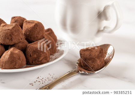 Chocolate truffle on a spoon closeup.  98385251