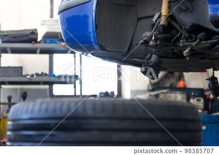 Car service center concept, vehicle raised on lift at maintenance station, auomobile repair, check up, repairing the car Car service center concept, vehicle raised on lift at maintenance station, auomobile repair, check up, repairing the car 98385707