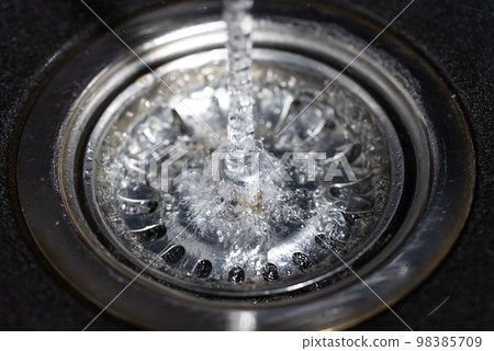 The water falling down from faucet to stainless sink and flow down to water hole, drink concept 98385709
