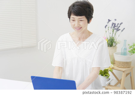 Middle-aged woman using a computer at home 98387192
