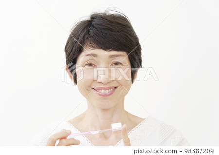 拿著牙刷的中年婦女的畫象白色背景 98387209