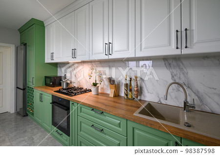 Green and white colored modern kitchen detail 98387598