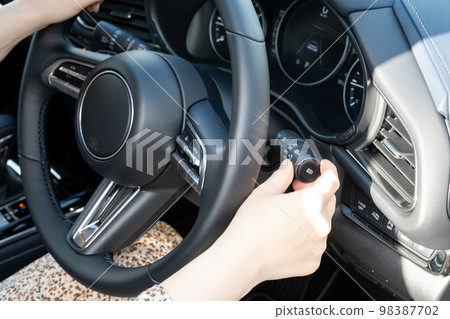 Image of operating a car's turn signal lever 98387702