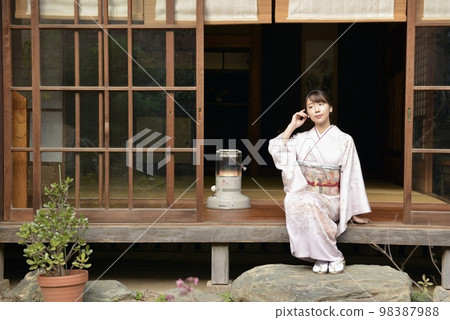 一位身穿和服的漂亮年輕女子在一棟舊私人住宅的門廊上擺姿勢 98387988