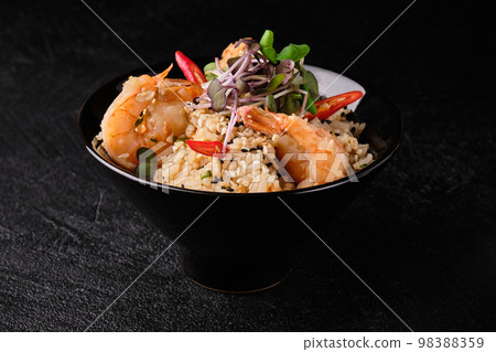 Thai Seafood Fried Rice or Kao Pad Sapparod on a black plate on black concrete background. 98388359