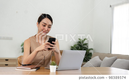 asian woman using mobile phone during checking an email or social media on internet. accounting financial concept asian woman using mobile phone during checking an email or social media on internet. accounting financial concept 98389374