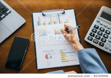 Woman accountant writing on business paper marketing statistic and data, Asian businesswoman working with paperwork charts and graphs and calculator, summary report planner, accounting concept Woman accountant writing on business paper marketing statistic and data, Asian businesswoman working with paperwork charts and graphs and calculator, summary report planner, accounting concept 98389806