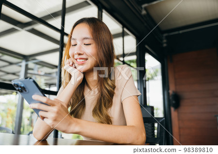 Beautiful Asian female hands holding and typing to communicate with others through on mobile phone, young woman using smartphone for shopping online at cafe coffee shop near windows in morning Beautiful Asian female hands holding and typing to communicate with others through on mobile phone, young woman using smartphone for shopping online at cafe coffee shop near windows in morning 98389810