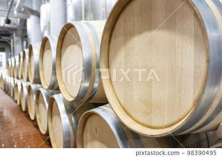 Large modern wine barrels at the winery, the concept of a large factory, production. Silver colored barrels, silver pipes on the ceiling. Large modern wine barrels at the winery, the concept of a large factory, production. Silver colored barrels, silver pipes on the ceiling. 98390495