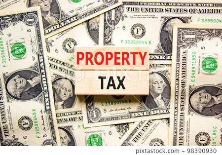 Property tax symbol. Concept words Property tax on wooden blocks. Beautiful background from dollar bills. Business and property tax concept. Copy space. 98390930