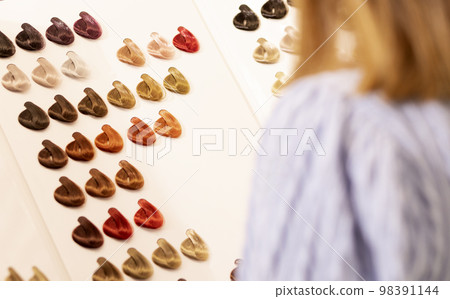 Hairdresser salon Woman chooses, looks at hair color samples on palette swatch book in stylist office or home. Beautician, dyeing or changing hair colour, natural, non-toxic, safe haircare concept Hairdresser salon Woman chooses, looks at hair color samples on palette swatch book in stylist office or home. Beautician, dyeing or changing hair colour, natural, non-toxic, safe haircare concept 98391144