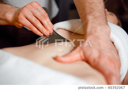 IASTM massage of the female abdominal muscles IASTM massage of the female abdominal muscles 98392067
