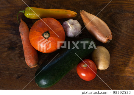 Many rustic, colorful, market fresh and organic healthy vegetables on an old weathered wooden paneled table top background. 98392523