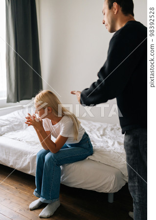 Vertical shot of frustrated blonde female tired of argument ignore aggressive husband shouting at wife. Stressed blonde woman annoyed with jealous boyfriend. Young couple quarrelling yelling at home. Vertical shot of frustrated blonde female tired of argument ignore aggressive husband shouting at wife. Stressed blonde woman annoyed with jealous boyfriend. Young couple quarrelling yelling at home. 98392528
